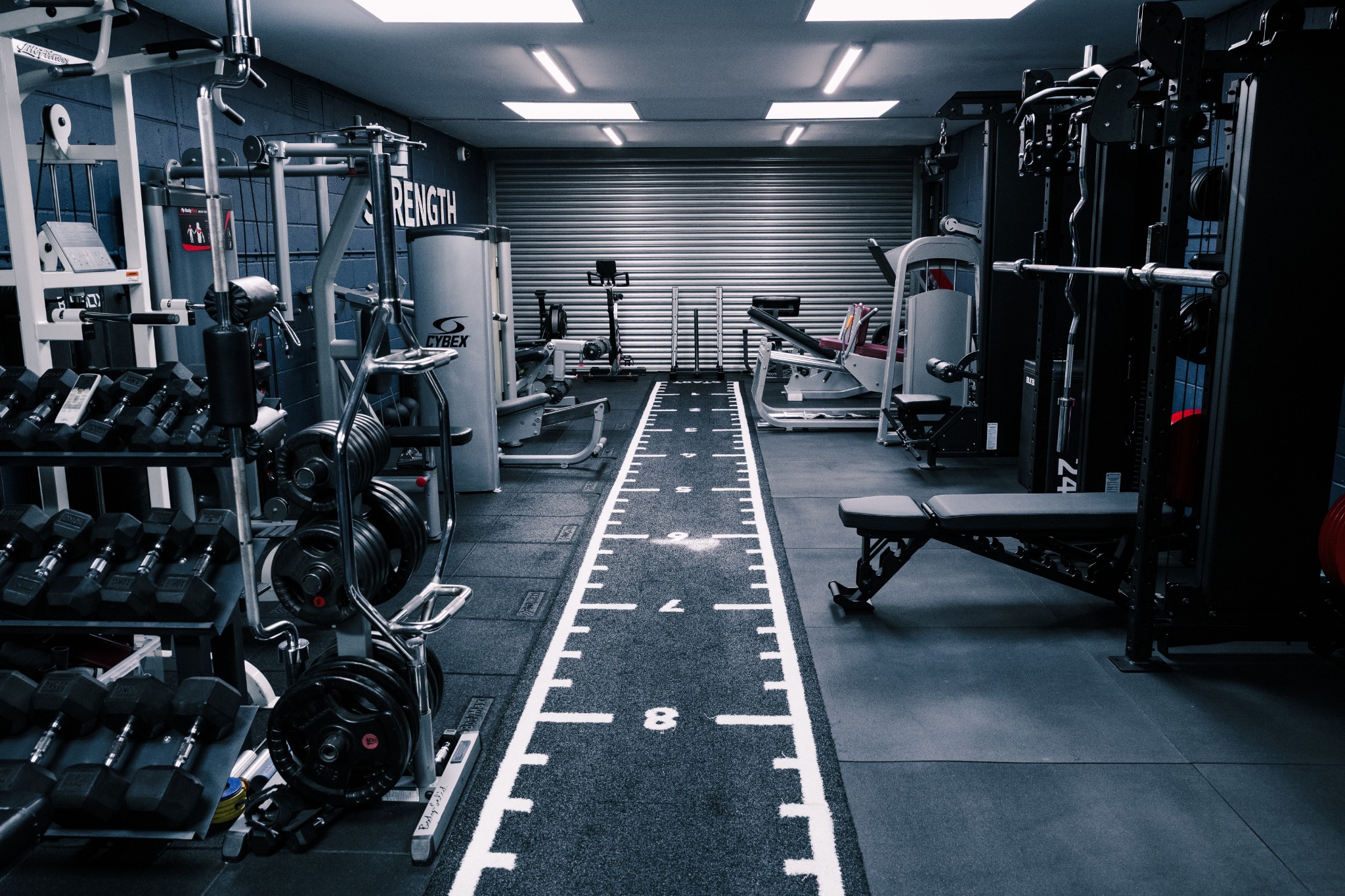 Strength & Co studio with weights, training machines and the floor track